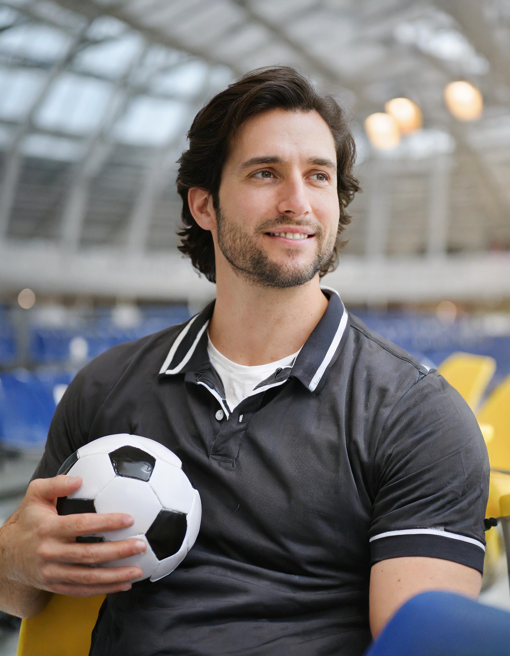 Fröhliche Menschen, die Fußball spielen oder an einem Sportevent teilnehmen