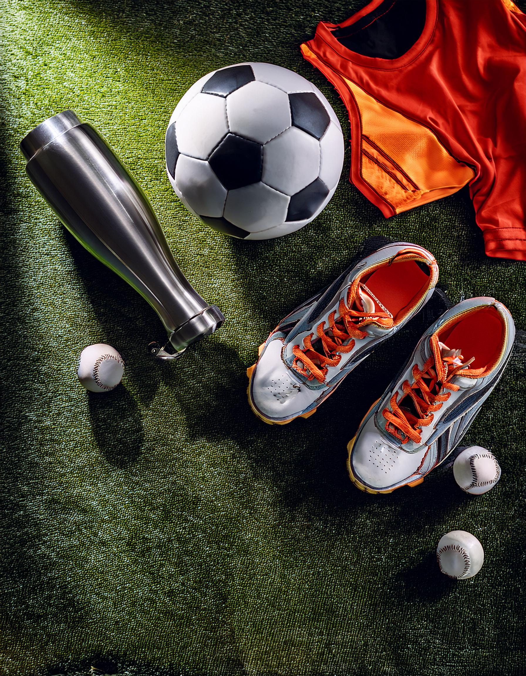 Fußballspiel auf einem grünen Spielfeld mit jubelnden Fans im Hintergrund